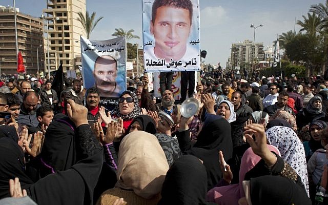 Egyptian protesters chant anti-President Mohammed Morsi slogans and carry posters with pictures of victims of recent violence in Port Said, Egypt, on Friday (photo credit: AP/Nasser Nasser)