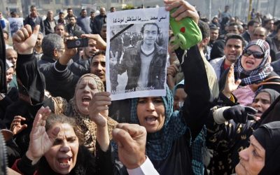 Egyptian relatives of Mohammed el-Gindy, a 28-year-old activist, who died early Monday of wounds sustained during clashes last Friday near the presidential palace, display his picture as they shout anti-president Morsi slogans during his funeral procession in Tahrir Square, Cairo, Egypt, Monday, Feb. 4 (photo credit: AP/Amr Nabil)