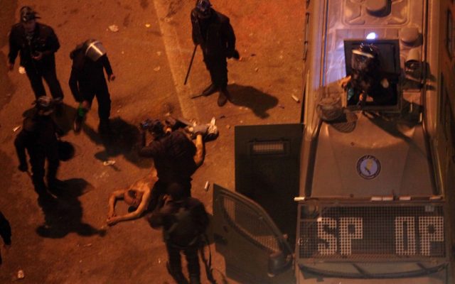Egyptian riot police beat a man, after stripping him, and before dragging him into a police van, during clashes next to the presidential palace in Cairo, Egypt, on Friday, Feb. 1, 2013. (photo credit: AP/Khalil Hamra) Egyptian riot police beat a man, after stripping him, and before dragging him into a police van, during clashes next to the presidential palace in Cairo, Egypt, on Friday, Feb. 1, 2013. (photo credit: AP/Khalil Hamra)