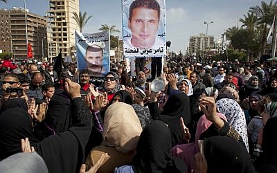Egyptian protesters chant anti-Morsi slogans and carry posters with pictures of victims of recent violence and their names in Port Said, Egypt, February 22, 2013. (photo credit: AP/Nasser Nasser)