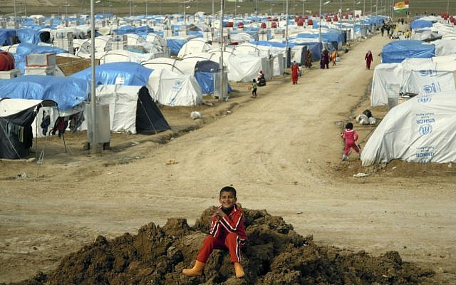 A Syrian Kurdish refugee plays on a pile of dirt in the Dumiz refugee camp in northern Iraq. (photo credit: AP/Karin Laub)