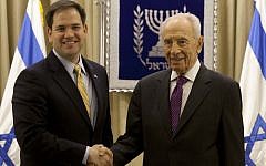 President Shimon Peres, right, shakes hands for photographers with Republican Senator Marco Rubio during their meeting in Jerusalem in February, 2013 (photo credit: AP/Sebastian Scheiner)