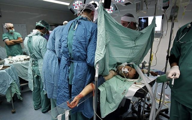 Palestinian surgeons operate on 24-year-old Helmi Abdul-Aziz in the West Bank city of Nablus, Saturday, February 23. (photo credit: AP/Nasser Ishtayeh) Palestinian surgeons operate on 24-year-old Helmi Abdul-Aziz in the West Bank city of Nablus, Saturday, February 23. (photo credit: AP/Nasser Ishtayeh)
