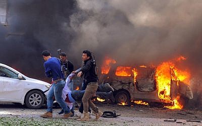 In this photo provided by the Syrian official news agency SANA, Syrian security agents carry a body following a huge explosion that shook central Damascus, Syria, Thursday, Feb. 21, 2013 (photo credit: AP/SANA)