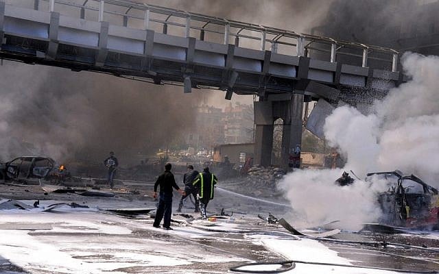 Syrian fire fighters extinguish burning cars after a huge explosion that shook central Damascus on Thursday (photo credit: AP/SANA)
