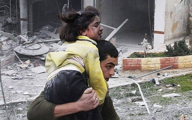 Syrian man carries his sister, who was wounded in a government airstrike, in Aleppo, Syria, on Sunday, February 3, 2013. (photo credit: AP Photo/Abdullah al-Yassin)