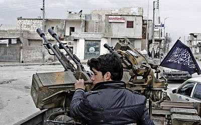 A Free Syrian Army fighter sits behind an anti-aircraft weapon in Aleppo, Syria (photo credit: AP/Abdullah al-Yassin)