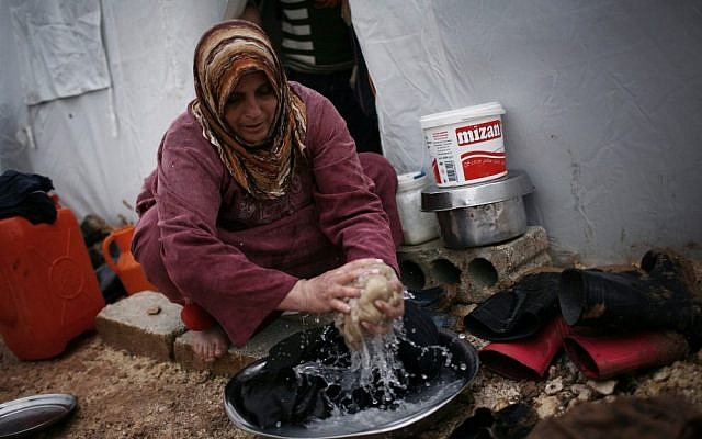 A displaced Syrian woman washes some clothes in front of her tent in the Azaz camp for displaced people, north of Aleppo province, Syria, Monday, Feb. 18, 2013 (photo credit: AP/Manu Brabo) A displaced Syrian woman washes some clothes in front of her tent in the Azaz camp for displaced people, north of Aleppo province, Syria, Monday, Feb. 18, 2013 (photo credit: AP/Manu Brabo)