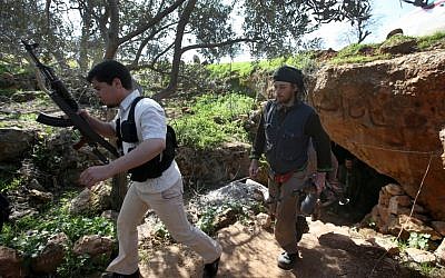 Free Syrian Army fighters from the Knights of the North brigade leave one of their caves to reconnaissance a Syrian army forces base of al-Karmid, at Jabal al-Zaweya, in Idlib province, Syria, Wednesday, Feb. 27 (Photo credit: AP/Hussein Malla)