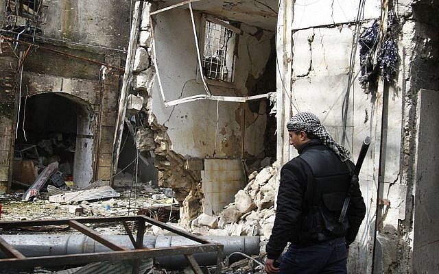 A Free Syrian Army fighter walks past destroyed shops in Aleppo, Syria, on Friday, February 8, 2013. (photo credit: AP/Abdullah Al-Yassin) A Free Syrian Army fighter walks past destroyed shops in Aleppo, Syria, on Friday, February 8, 2013. (photo credit: AP/Abdullah Al-Yassin)