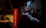 Members of the jury of the World Press Photo contest listen to questions during a press conference as the winning picture by Paul Hansen, Sweden, for Dagens Nyheter, is projected on a screen in Amsterdam in February. (photo credit: AP/Peter Dejong)