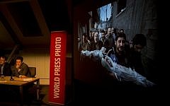 Members of the jury of the World Press Photo contest listen to questions during a press conference as the winning picture by Paul Hansen, Sweden, for Dagens Nyheter, is projected on a screen in Amsterdam in February. (photo credit: AP/Peter Dejong)