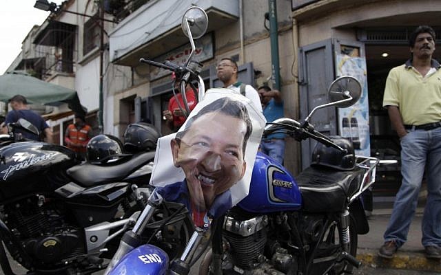 A poster of Venezuela's President Hugo Chavez decorates a motorbike near the military hospital where Chavez is allegedly receiving treatment in Caracas, Venezuela, on Wednesday (photo credit: AP/Ariana Cubillos)