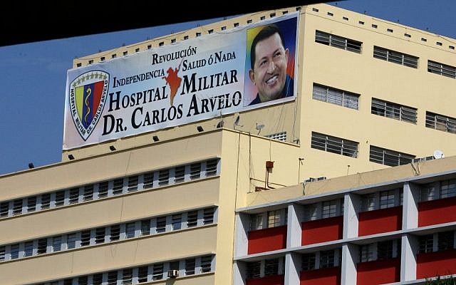 A banner bearing a photo of Venezuelan President Hugo Chavez is displayed on the military hospital where the ailing leader is continuing his recovery from surgery related to an unspecified cancer (photo credit: AP/Fernando Llano) A banner bearing a photo of Venezuelan President Hugo Chavez is displayed on the military hospital where the ailing leader is continuing his recovery from surgery related to an unspecified cancer (photo credit: AP/Fernando Llano)