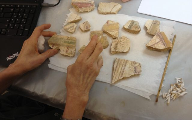 The hands of Connie Kestenbaum Green, piecing together the stucco trim from Herod's VIP room (photo credit: Jessica Steinberg/Times of Israel)