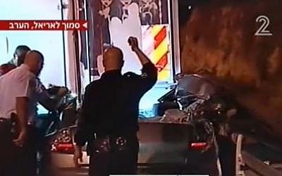 Police inspect the damage to a car that collided with a truck after Palestinians hurled rocks at the car, Thursday, March 14. (photo credit: image capture Channel 2)
