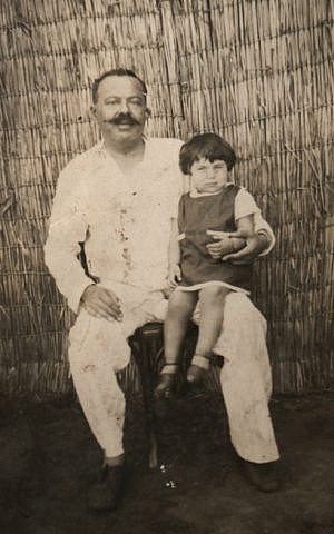 Avi Casuto sits on his father's lap in Cairo before their departure to Israel in 1956. (Courtesy of Ada Aharoni via JTA)
