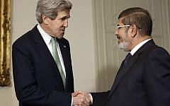 US Secretary of State John Kerry, left, shakes hands with Egyptian President Mohammed Morsi at the Presidential Palace in Cairo, Egypt, in March. (photo credit: AP/Jacquelyn Martin)
