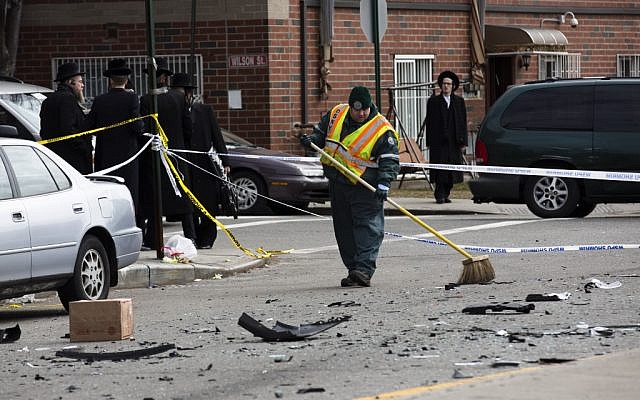 A worker clears debris from a fatal accident that claimed the lives of two expectant parents, Sunday, March 3, 2013, in the Brooklyn borough of New York. (photo credit: AP/John Minchillo) A worker clears debris from a fatal accident that claimed the lives of two expectant parents, Sunday, March 3, 2013, in the Brooklyn borough of New York. (photo credit: AP/John Minchillo)