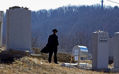 A person walks towards the graves of Nathan and Raizy Glauber, at the Satmar Cemetery 2 in Kiryas Joel, New York, on Monday, March 4, 2013. (photo credit: AP Photo/Craig Ruttle)