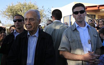 President Shimon Peres is surrounded by bodyguards during a visit to Kibbutz Kfar Aza in 2009 (photo credit: Tsafrir Abayov/Flash90)