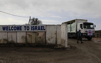UN soldiers watch as an ICRC (International Committee of the Red Cross) truck loaded with apples crosses at the Quneitra crossing between the Israeli Golan Heights and Syria, February 2011. (Tsafrir Abayov/Flash90)