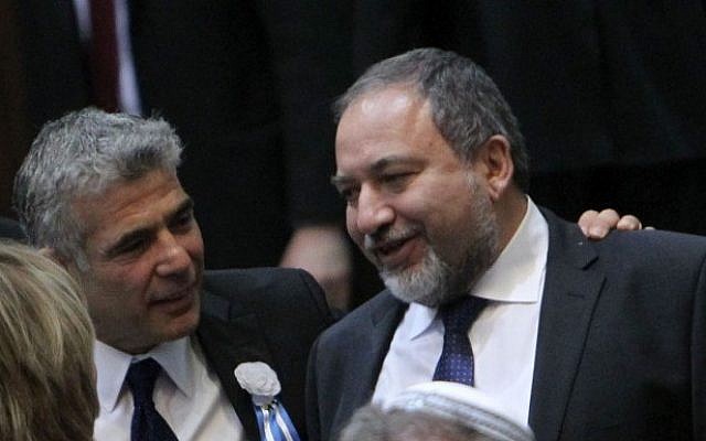Yesh Atid party leader Yair Lapid seen with his hand on the shoulder of former foreign minister Avigdor Liberman during the opening session of Israel's 19th parliament, held at the Knesset, February 5 (photo credit: Miriam Alster/Flash90)