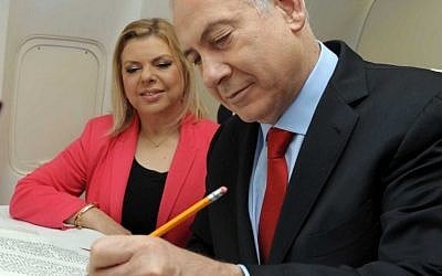 Benjamin Netayahu writes a letter in a Torah scroll on an airplane as he makes his way to visits the Czech Republic with his wife Sarah, May 17 2012. (photo credit: Avi Ohayon/GPO/Flash90)