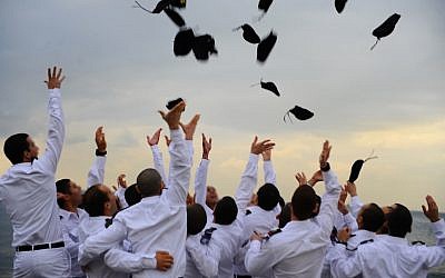 Graduating naval officers of the Israeli Navy toss their hats during a graduation ceremony (Photo credit: Ofir Shifrin/ IDF Spokesperson/Flash 90)