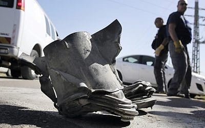 Israeli bomb technicians inspect the remains of a long-range rocket fired from the northern Gaza Strip at the coastal city of Ashkelon, Tuesday. (photo credit: Tsafrir Abayov/Flash90)