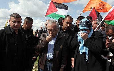Palestinian Authority Prime Minister Salam Fayyad reacts after inhaling tear gas fired during clashes between hundreds of Palestinian youths and Israeli security forces in the West Bank village of Bil'in on Friday, following a large march which headed toward the security fence in support of Palestinian prisoners held in Israeli jails, and marking eight years of weekly protests which kicked off in February 2005. (photo credit: Issam Rimawi/Flash90)