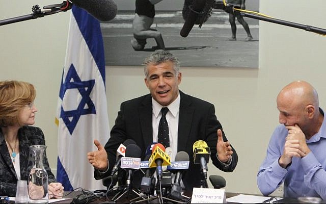 Yair Lapid, leader of Yesh Atid, is flanked by party members as he starts his faction's meeting on coalition talks at the Knesset Monday (photo credit: Miriam Alster/Flash90)