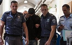 A Jewish teenager who is suspected of participating in a stone-throwing attack on the vehicle of an Arab woman in Jerusalem is being brought to a judge in the Jerusalem Magistrates Court, on March 7, 2013. (photo credit: Flash90)