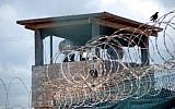 A guard stands duty in a tower over Guantanamo Bay's Detention Camp Delta, in 2007. (Army Sgt. Joseph Scozzar/Public Domain)