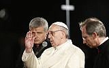 Pope Francis delivers his blessing during the Via Crucis (Way of the Cross) torchlight procession celebrated in front of the Colosseum on Good Friday in Rome, Friday, March 29, 2013. Pope Francis is sitting in silent prayer during this year's Good Friday procession, which is re-enacting Christ's crucifixion and recalling the wars and "violent fundamentalism" that are devastating the Middle East today. The Good Friday procession at Rome's Colosseum is one of the most dramatic rituals of Holy Week, when Christians commemorate the death and resurrection of Christ. (photo credit: AP/Andrew Medichini)