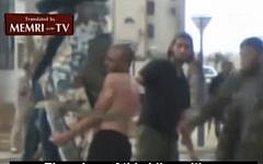 Men in civilian attire administer lashings to a man in Sirte. (photo credit: MEMRI)