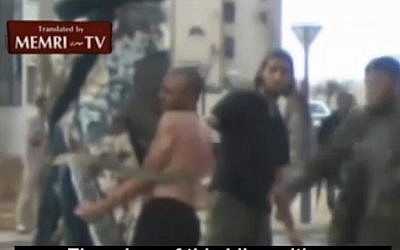 Men in civilian attire administer lashings to a man in Sirte. (photo credit: MEMRI)