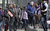 An Egyptian protester wearing a Guy Fawkes mask runs during clashes with security at the entrance of Tahrir Square, the focal point of the Egyptian revolution, in Cairo, Egypt, Tuesday, March 5, 20 (photo credit: AP/Amr Nabil)