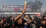 Egyptian soccer fans of Al-Ahly club celebrate in front of their club in Cairo, Egypt, Saturday. An Egyptian court confirmed death sentences against 21 people for their role in a deadly 2012 soccer riot that killed more than 70 people in the city of Port Said. Banner at background showing some pictures of the victims with Arabic that reads, "we will never forget you." (AP Photo/Amr Nabil)