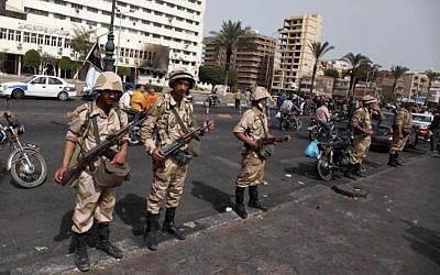 Egyptian army soldiers stand guard as they take control of the state security building after several days of clashes between protesters and riot police in Port Said, Egypt, Friday, March 8, 2013. (photo credit: AP/Khalil Hamra)