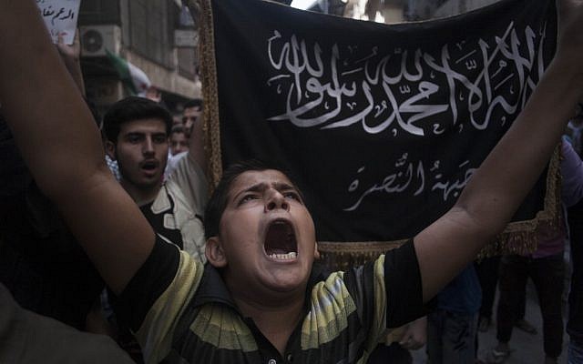 In this Friday, Sept. 21, 2012 file photo, a Syrian boy shouts slogans against the regime in front of a flag of the armed Islamic opposition group, the Nusra front, during a demonstration in the Bustan al-Qasr neighborhood of Aleppo, Syria (photo credit: Manu Brabo/AP) In this Friday, Sept. 21, 2012 file photo, a Syrian boy shouts slogans against the regime in front of a flag of the armed Islamic opposition group, the Nusra front, during a demonstration in the Bustan al-Qasr neighborhood of Aleppo, Syria (photo credit: Manu Brabo/AP)