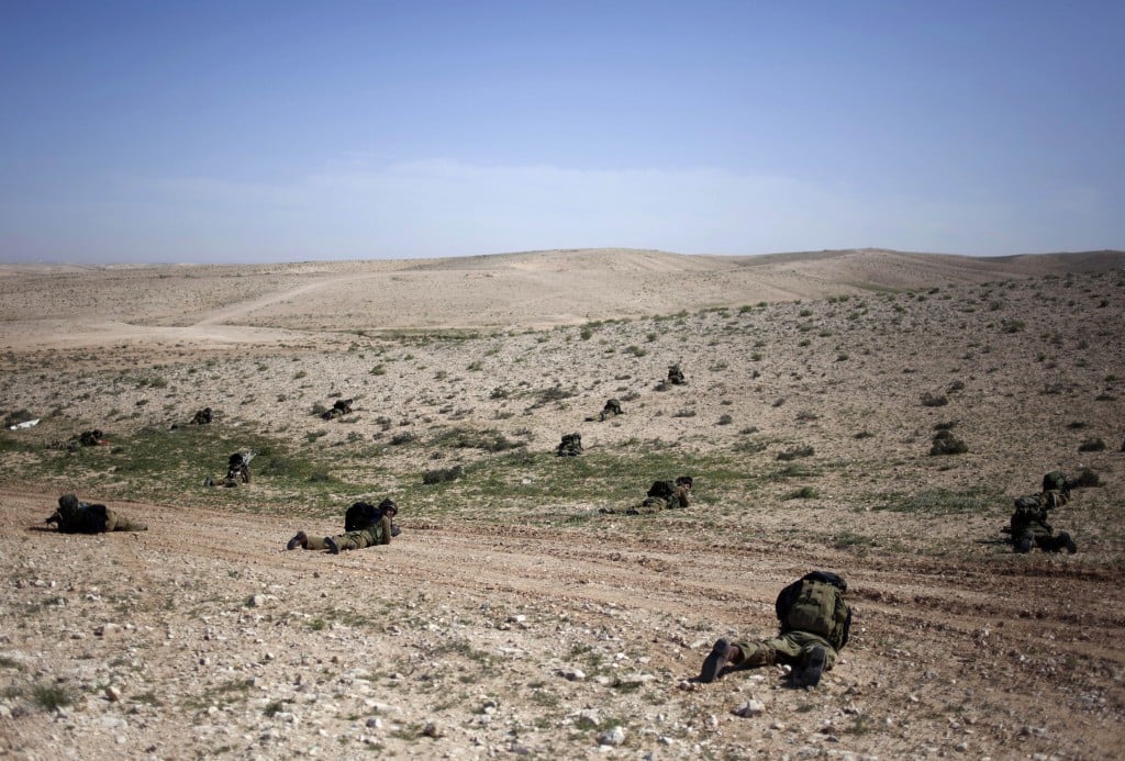 Israeli soldiers lay on the ground as they participate in a drill near Revivim, southern Israel, Thursday, March 7, 2013 (photo credit: AP/Sebastian Scheiner)