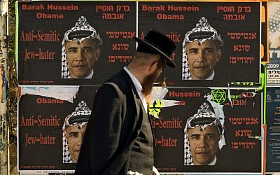 An Ultra Orthodox Jewish man walks past posters depicting US President Barack Obama wearing a traditional Arab headdress, in Jerusalem, 2009. President Barack Obama’s vow to take his message straight to the public during his first presidential visit to Israel next week will be a tough sell with many Israelis who consider him naive, too soft on the nation’s enemies and even hostile to Prime Minister Benjamin Netanyahu. (AP Photo/Sebastian Scheiner, File)