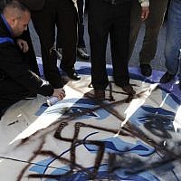 Palestinian activists vandalize a poster of US President Barack Obama in the West Bank city of Bethlehem, Monday, March 18, 2013. (photo credit: AP/Nasser Shiyoukhi)