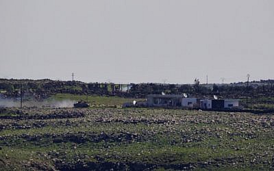 A Syrian Army tank moves toward the Syrian village of Jamlah in the southern province of Daraa, Syria, as seen from the Israeli-controlled Golan Heights, Thursday, March 7, 2013 (photo credit: AP/Ariel Schalit)