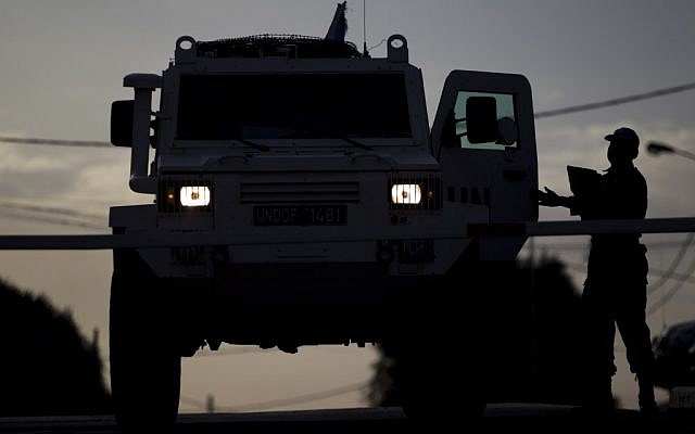 A UN peacekeeper checks a armored vehicle as it leaves from the UNDOF Ziouani camp to cross to Syria at the Quneitra Crossing between Syria and the Israeli-controlled Golan Heights,on Friday, March 8, 2013. (photo credit: AP/Ariel Schalit) A UN peacekeeper checks a armored vehicle as it leaves from the UNDOF Ziouani camp to cross to Syria at the Quneitra Crossing between Syria and the Israeli-controlled Golan Heights,on Friday, March 8, 2013. (photo credit: AP/Ariel Schalit)