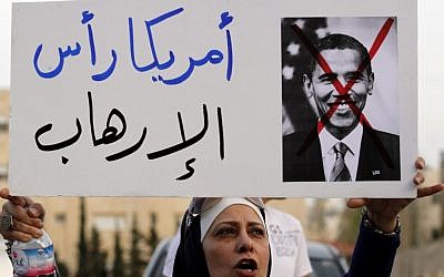 A Jordanian protester holds a placard that reads "America is the head of terrorism," during a protest near the Israeli Embassy against the visit by US President Obama to the region, in Amman, Jordan, Thursday, March 21, 2013. (photo credit: AP/Raad Adayleh)