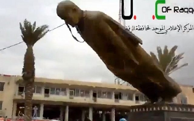 A statue of former Syrian president Hafez Assad is pulled down in a central square in Raqqa, Monday. (photo credit: Ugarit News/AP) A statue of former Syrian president Hafez Assad is pulled down in a central square in Raqqa, Monday. (photo credit: Ugarit News/AP)