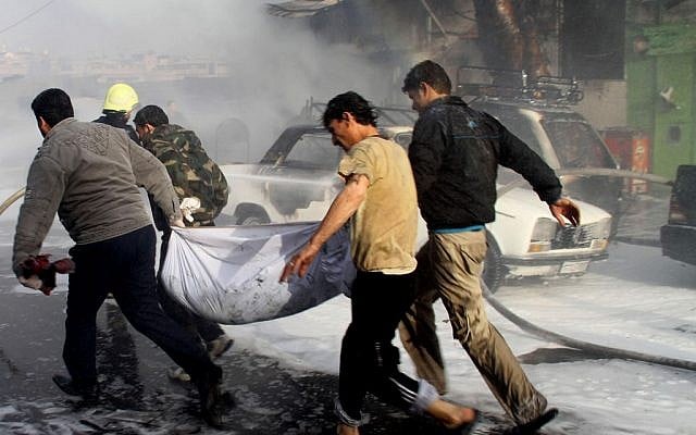 In this photo released by the Syrian official news agency SANA, Syrian citizens carry a dead body, at the scene where two mortar rounds exploded near an orphanage, at al-Boukhtyar area, in Damascus (photo credit: AP/SANA) In this photo released by the Syrian official news agency SANA, Syrian citizens carry a dead body, at the scene where two mortar rounds exploded near an orphanage, at al-Boukhtyar area, in Damascus (photo credit: AP/SANA)