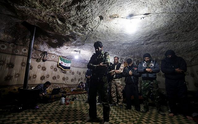 Free Syrian Army fighters pray inside a cave at Jabal al-Zaweya in Idlib, Syria, Sunday Feb. 24, 2013 (photo credit: AP/Hussein Malla)